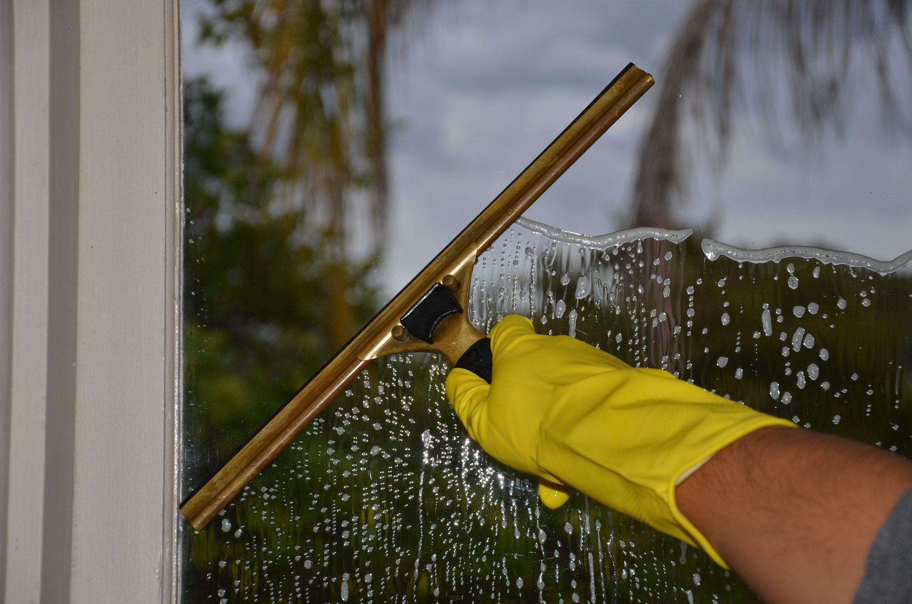 Window cleaning technician using squeegee technique